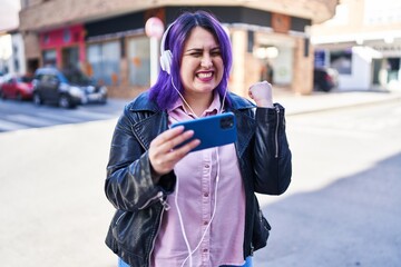 Young beautiful plus size woman smiling confident playing video game at street