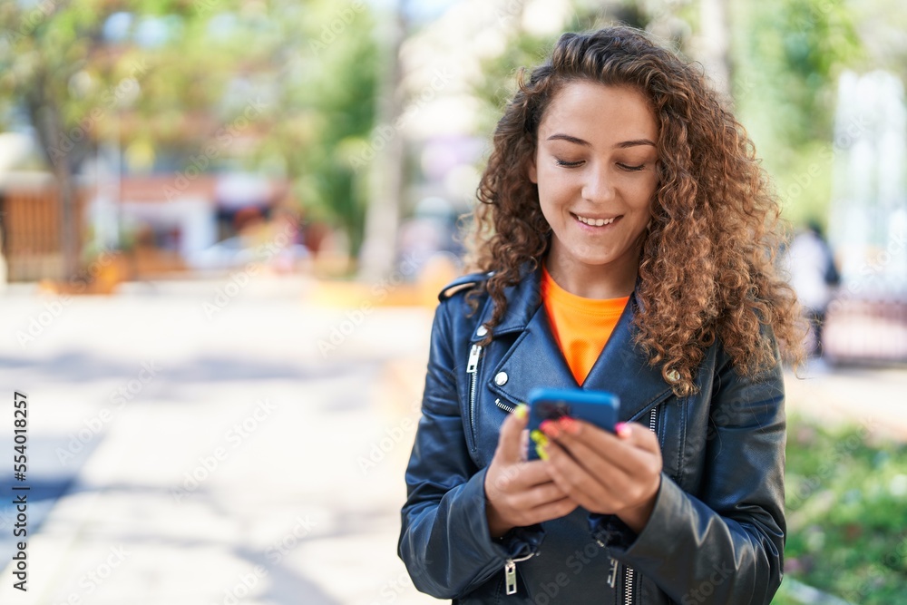 Poster Young beautiful hispanic woman smiling confident using smartphone at park