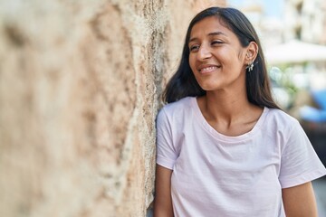 Young beautiful hispanic woman smiling confident looking to the side at street