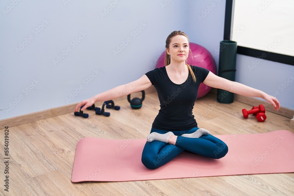 Poster young blonde woman smiling confident training yoga at sport center