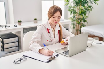 Young blonde woman wearing doctor uniform prescribe pills treatment at clinic