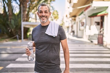 Middle age hispanic man smiling confident wearing sportswear at street