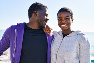 Man and woman couple wearing sportswear standing together at seaside