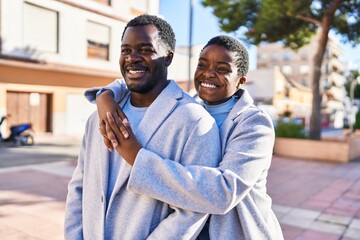 Man and woman couple hugging each other standing at street