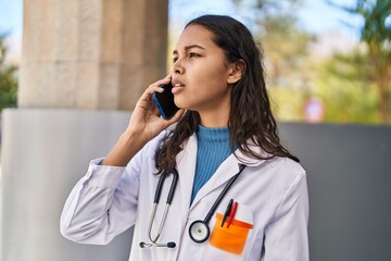 Young african american woman doctor talking on the smartphone at street