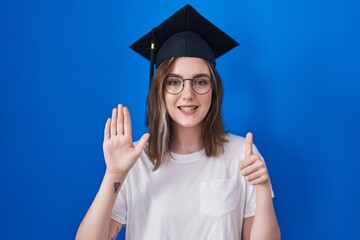 Blonde caucasian woman wearing graduation cap showing and pointing up with fingers number six while smiling confident and happy.