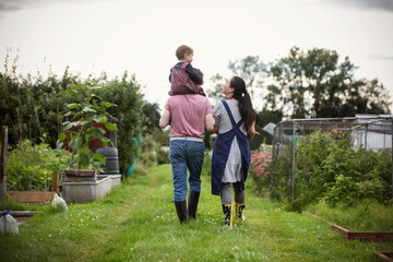 Family walking in backyard vegetable garden