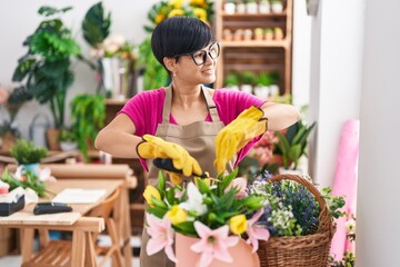 Middle age chinese woman florist cutting plants at flower shop