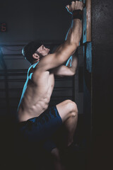 muscular male athlete climbing the pegboard in cross training gym. box cross training. 