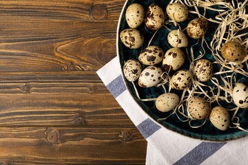 Quail eggs in a plate on a dark brown wooden background. Healthy food. Diet. top view. free space.