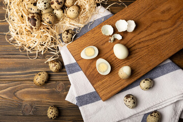 Quail eggs raw and boiled on a brown wooden background. Healthy food. Diet. top view. free space.