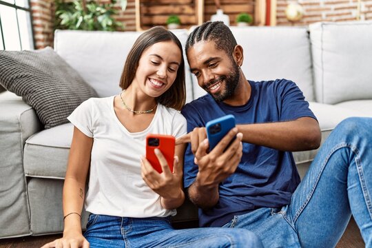 Man and woman couple smiling confident using smartphone at home