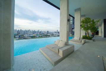 Swimming pool on rooftop of hotel apartment building in Bangkok downtown skyline, urban city view. Relaxing in summer season in travel holiday vacation concept. Recreation lifestyle.