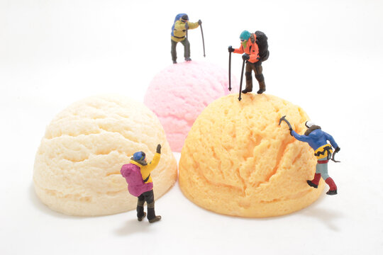 A Mini Of Figurines Climbing Ice Cream Ball