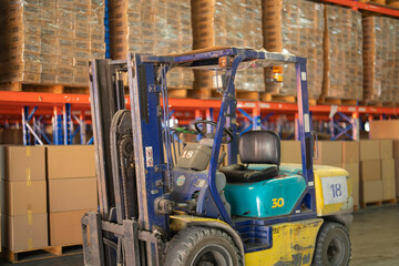 Fork lift truck with pallet car vehicle working of large warehouse retail store industry. Rack of furniture and stock storage. Interior of cargo in ecommerce and logistic concept. Depot transportation