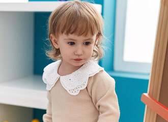 Adorable hispanic girl standing with relaxed expression at kindergarten