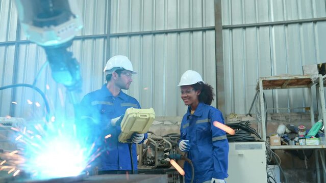 Young female engineers are completing apprenticeships and learning from senior engineers. When the robotic welding equipment started up, there was a tiny jolt.