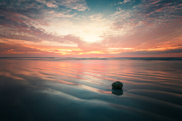 Sonnenaufgang am Meeresstrand mit Kokosnuss im Wasser