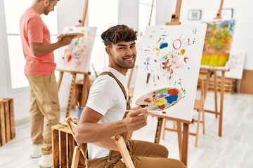 Two hispanic men couple smiling confident drawing at art studio