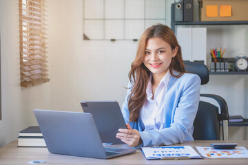 Marketing, finance, accounting, planning, female accountant portrait with beautiful smile wearing team blue suit using laptop calculator and documents, charts, graphs In the company analysis is profit