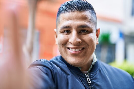 Young latin man smiling confident making selfie by camera at street
