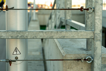 Modern metal fence made of metal profiles and cables. Connection and fastening of iron cables with a steel turnbuckles. Metal fastening of two steel rope. Fencing around the perimeter of the roof