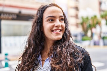 Young hispanic woman smiling confident standing at street