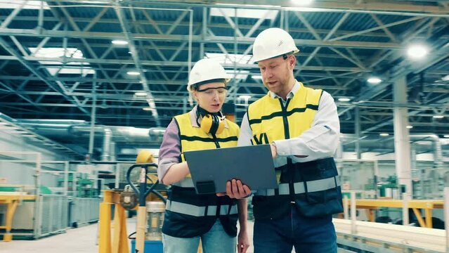 Fiberglass factory with two industrial engineers communicating