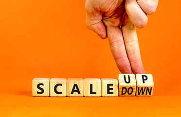 Scale up or down symbol. Concept words Scale up Scale down wooden cubes. Businessman hand....