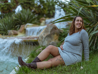 Pregnant Brazilian woman posing next to the fountains in a park in Montjuic, Barcelona