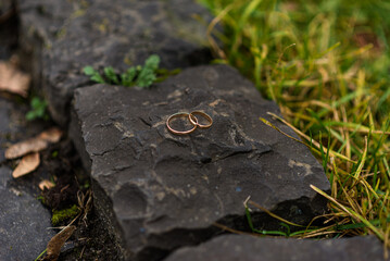 wedding rings in hand. Two wedding rings on the floor with contrast wedding rings on floor, on ground, on piano, in hand on grass or a stones,