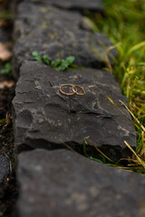 wedding rings in hand. Two wedding rings on the floor with contrast wedding rings on floor, on ground, on piano, in hand on grass or a stones,