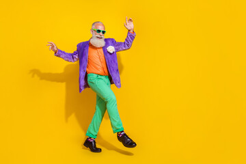 Fototapeta na wymiar Full length photo of funky handsome man wear purple velvet jacket having fun discotheque empty space isolated yellow color background