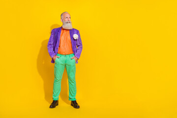 Full length photo of positive confident man wear purple velvet jacket looking empty space isolated yellow color background