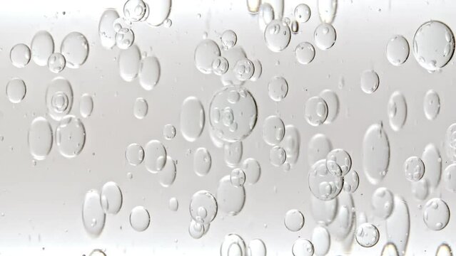 Transparent Cosmetic Gel Fluid With Molecule Bubbles and Oil Flowing in Glass Tube with Clear Liquid on White Background. Macro shot. Production Close-up. Slow Motion. High quality FullHD footage
