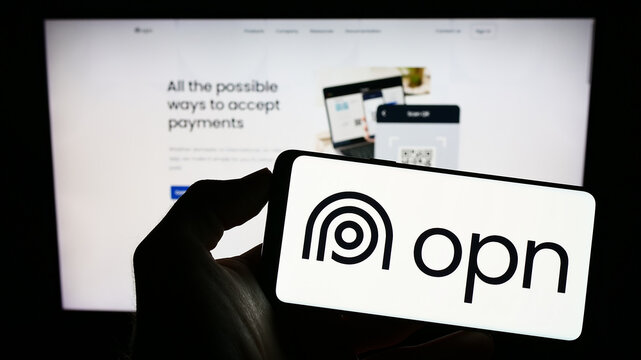 Stuttgart, Germany - 12-04-2022: Person holding cellphone with logo of Japanese payments company OPN Co. Ltd. on screen in front of business webpage. Focus on phone display.