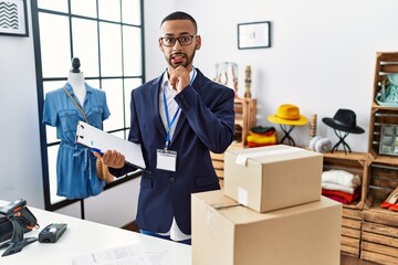 African american man working as manager at retail boutique thinking worried about a question,...