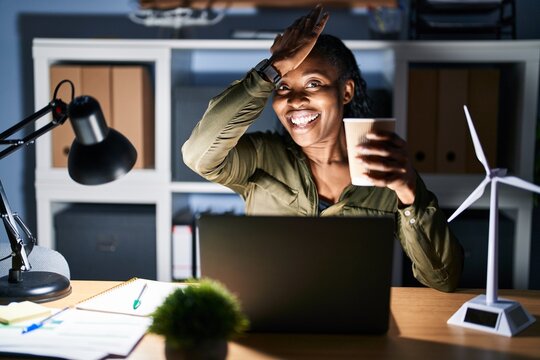 African woman working using computer laptop at night surprised with hand on head for mistake, remember error. forgot, bad memory concept.