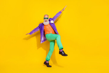 Full length photo of carefree positive pensioner wear trendy colorful outfit have fun go empty space isolated on yellow color background