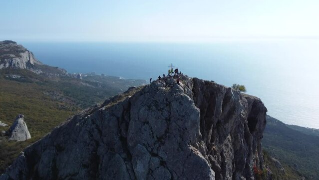 Group of tourists on top of mountain. Famous place at cross Alias Kaya, aerial view.