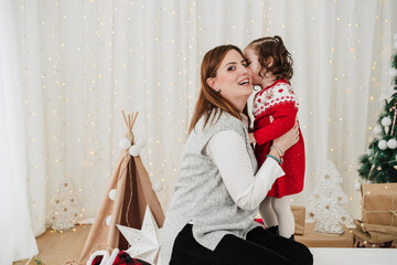 cute child kissing mother. enjoying christmas time at home