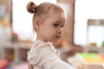 Adorable caucasian girl standing with relaxed expression at kindergarten