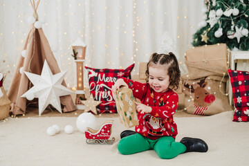 cute child girl at home holding christmas presents