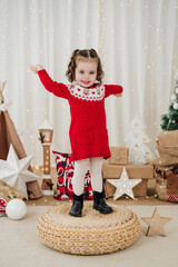 smiling cute little girl at home during christmas time standing on stool