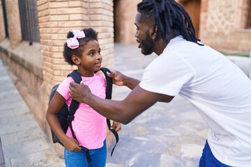 Father and daughter standing together speaking at school