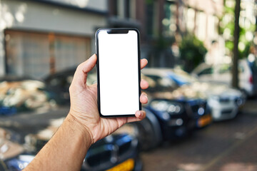 Man holding smartphone showing white blank screen at car parking