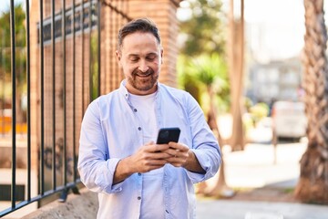 Young caucasian man smiling confident using smartphone at street