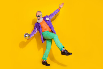 Plakat Full length photo of funky funny man wear purple velvet jacket holding discotheque ball having fun walking isolated yellow color background