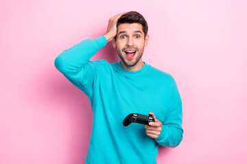 Photo portrait of attractive young man excited playstation hand touch head dressed stylish blue outfit isolated on pink color background