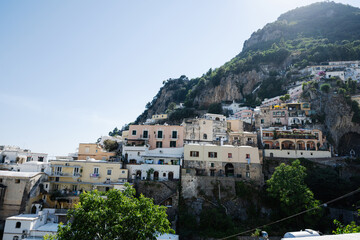 Fototapeta na wymiar Positano with hotels and houses on hills leading down to coast, comfortable beaches and azure sea on Amalfi Coast in Campania, Italy.